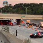 Police and traffic response on a closed freeway lane near a crash scene