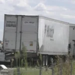 Closed highway lanes near a fatal crash scene with emergency vehicles and traffic blocked